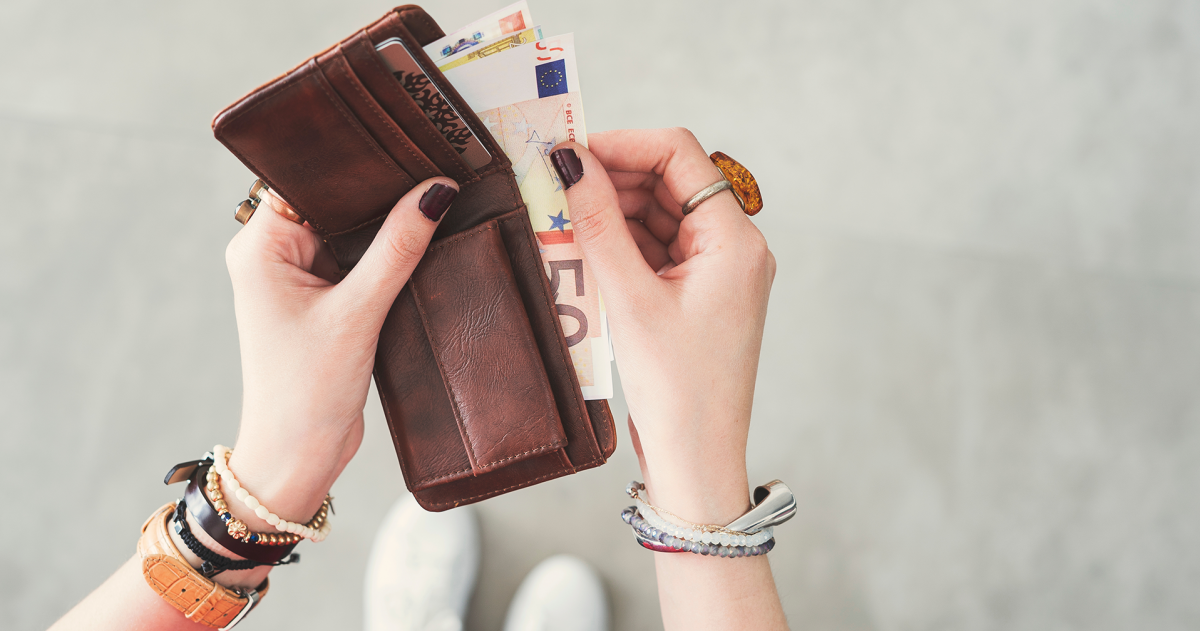 Prinsjesdag koopkracht; vrouw heeft een portomonnee in haar hand en haalt er briefgeld uit