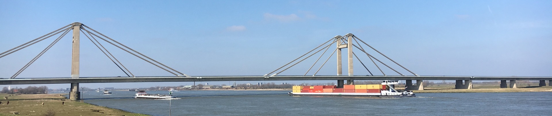 De PWA-brug met op de voorgrond de Waal en een schip